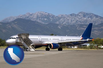 commercial aircraft at an airport, with mountainous background - with California icon