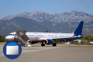 commercial aircraft at an airport, with mountainous background - with Colorado icon