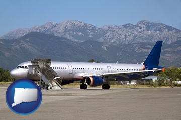 commercial aircraft at an airport, with mountainous background - with Connecticut icon
