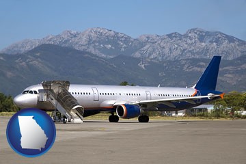 commercial aircraft at an airport, with mountainous background - with Georgia icon