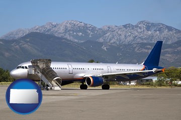 commercial aircraft at an airport, with mountainous background - with Kansas icon