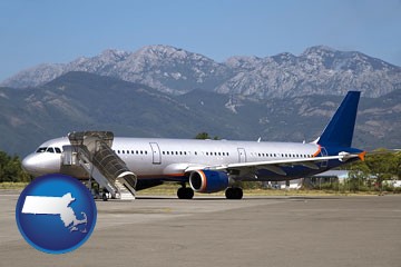 commercial aircraft at an airport, with mountainous background - with Massachusetts icon