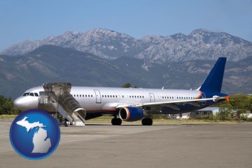 commercial aircraft at an airport, with mountainous background - with Michigan icon