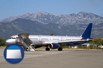 commercial aircraft at an airport, with mountainous background - with North Dakota icon