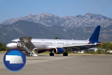 commercial aircraft at an airport, with mountainous background - with Nebraska icon