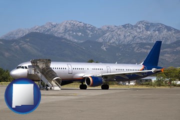commercial aircraft at an airport, with mountainous background - with New Mexico icon