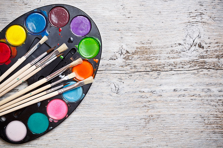 an artist palette and paintbrushes on a wooden board (large image)