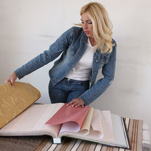 a woman looking at wallpaper samples