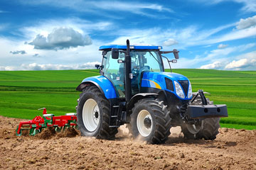 a blue farm tractor and a red cultivator