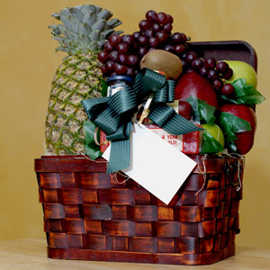 a gift basket with fruit, cheese, sausage, and preserves