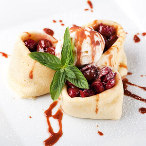gourmet dessert crepes with cherries and ice cream