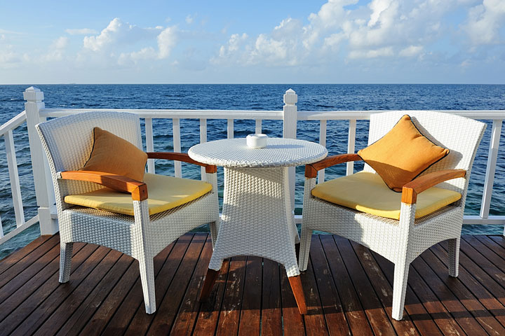 white, outdoor wicker furniture on an oceanfront deck (large image)