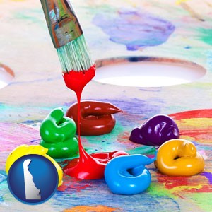 colorful oil paints and paintbrush - with Delaware icon