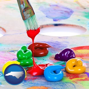 colorful oil paints and paintbrush - with North Carolina icon