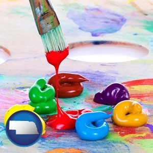 colorful oil paints and paintbrush - with Nebraska icon