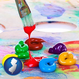 colorful oil paints and paintbrush - with New Jersey icon