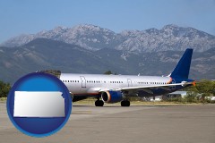 kansas map icon and commercial aircraft at an airport, with mountainous background