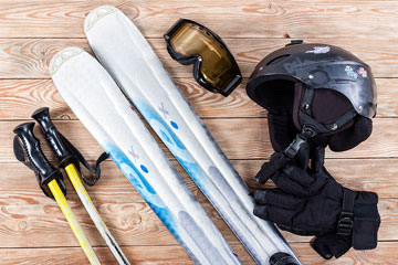 skis, ski poles, skiing gloves, goggles, and a helmet